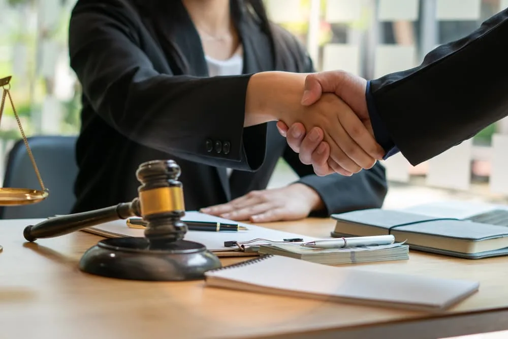 Client shaking hands with personal injury lawyer after legal advise.