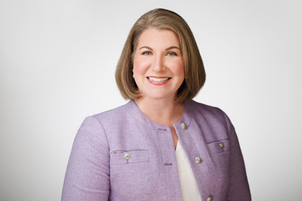 female lawyer in a purple suit smiling