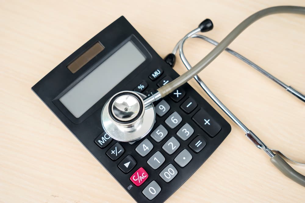 Closeup of calculator and stethoscope at the table. Health insurance cost concept