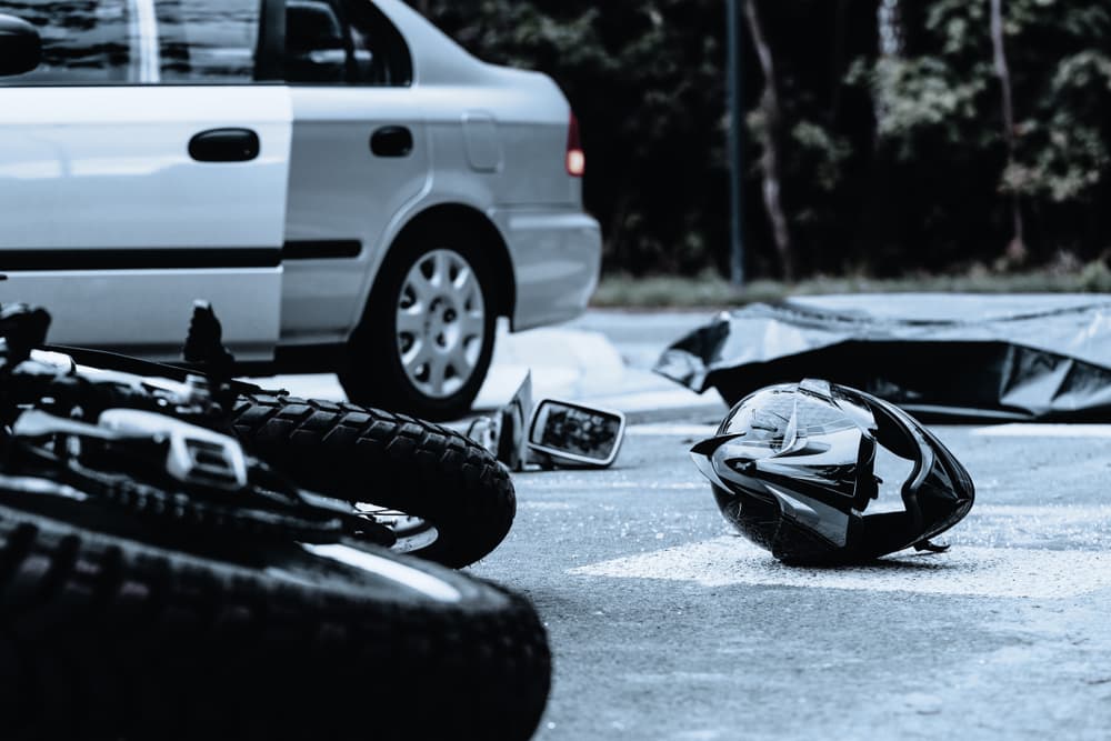 Motorcycle helmet on the street after terrible car crash.