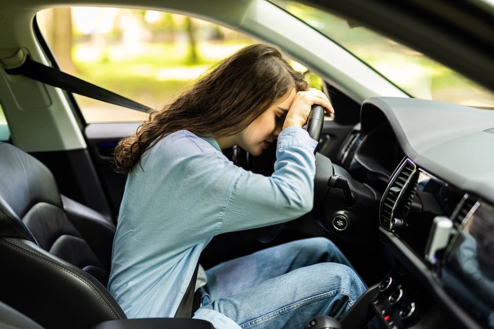 The scene emphasizes the dangers of driving while tired, highlighting the "don't drive drowsy" concept.