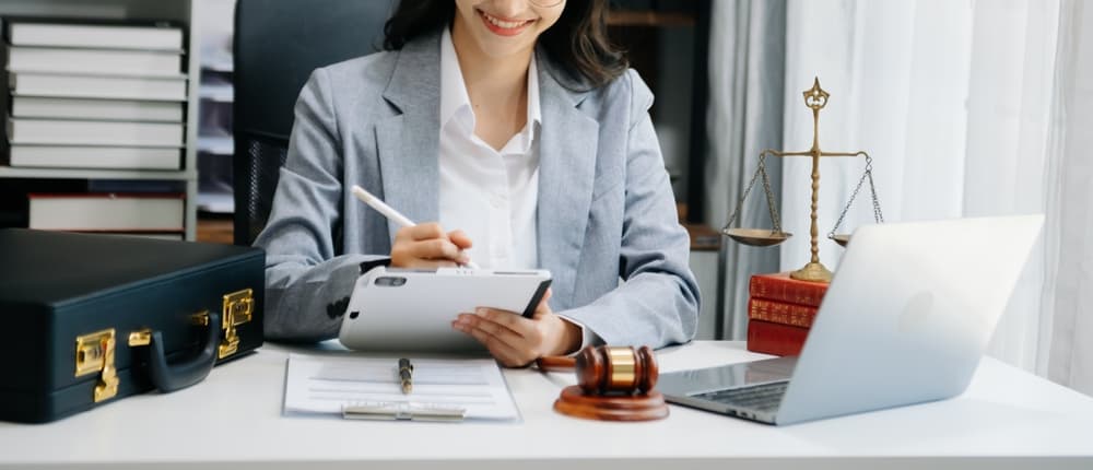 A female judge seated at a courtroom table, representing the concept of justice and law, with a gavel and legal documents in front of her, embodying authority and fairness in the legal system.