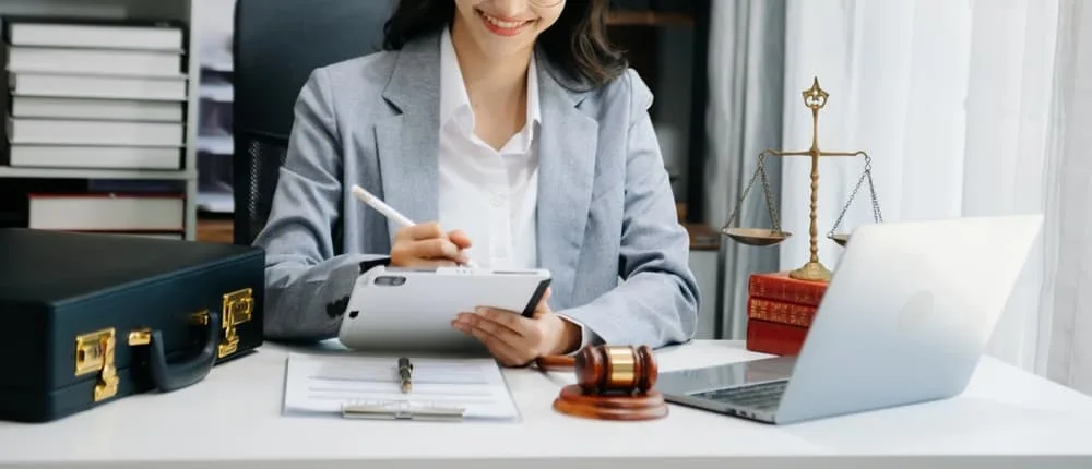A female judge seated at a courtroom table, representing the concept of justice and law, with a gavel and legal documents in front of her, embodying authority and fairness in the legal system.