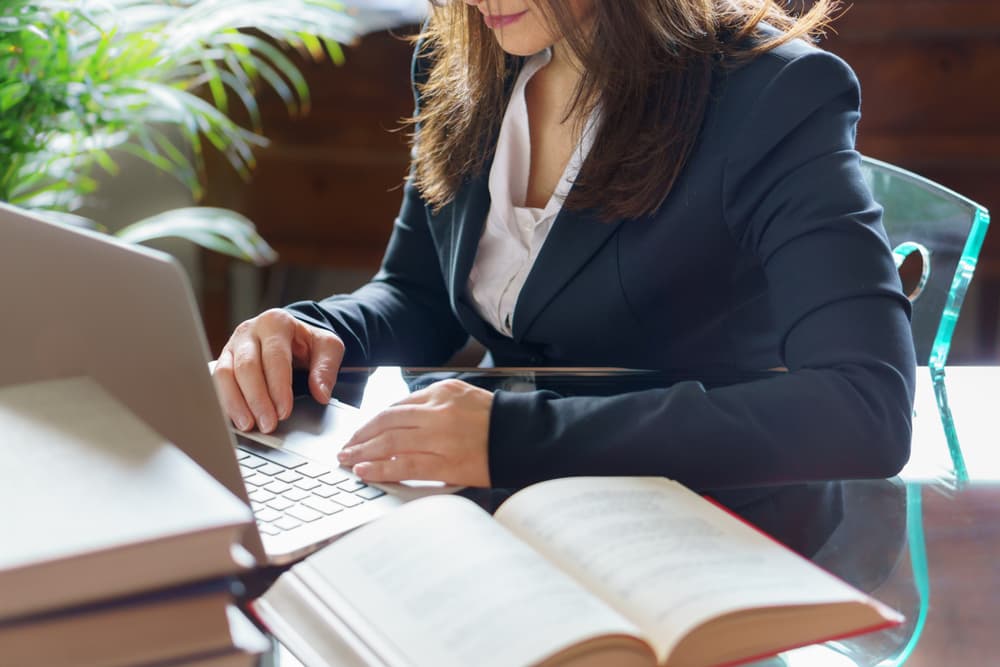 A woman works on a laptop, embodying the concepts of business, legal advice, and justice.