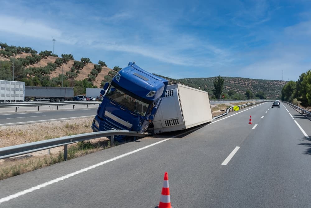 A refrigerated semi-trailer truck involved in an accident has overturned in the median by the exit of the highway.