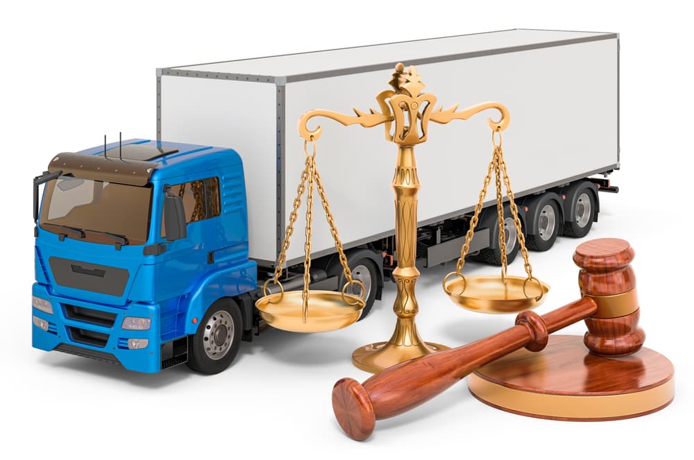 A truck with a wooden gavel and scales of justice on its bed, representing the intersection of transportation and legal justice.