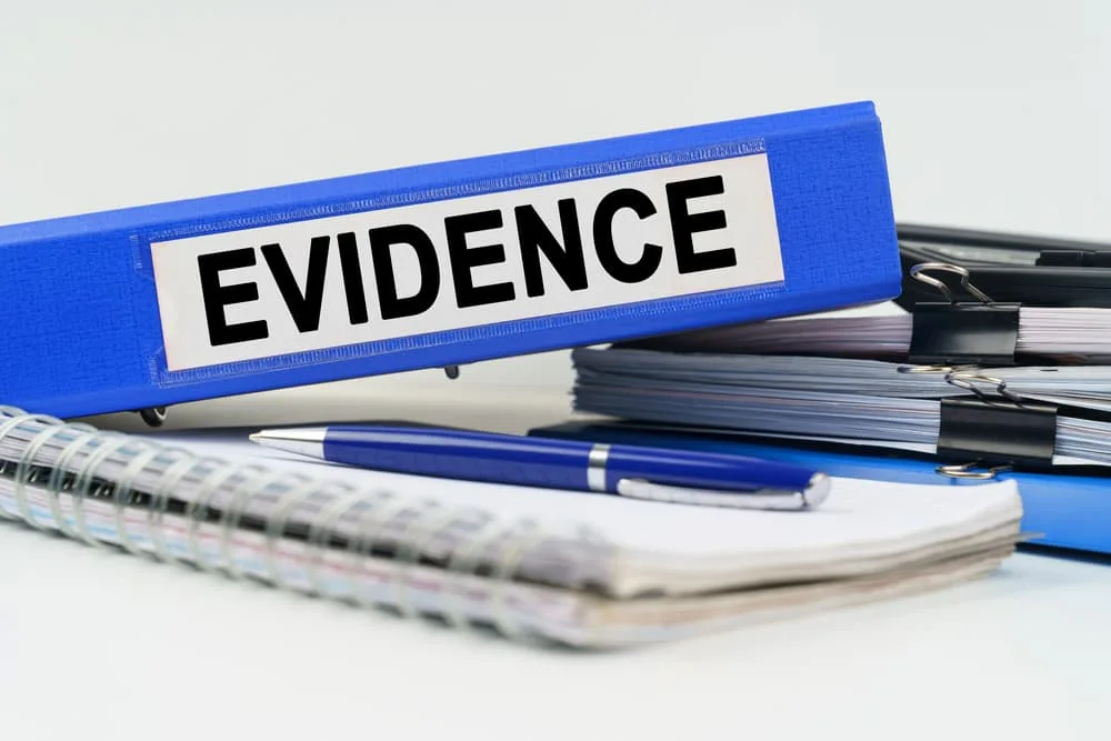 On the table are a notebook, a pen, documents and a folder with the inscription - EVIDENCE