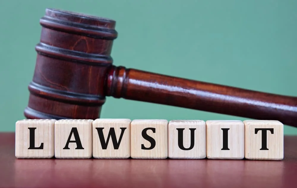Word Lawsuit made with wooden blocks and judge's gavel in background