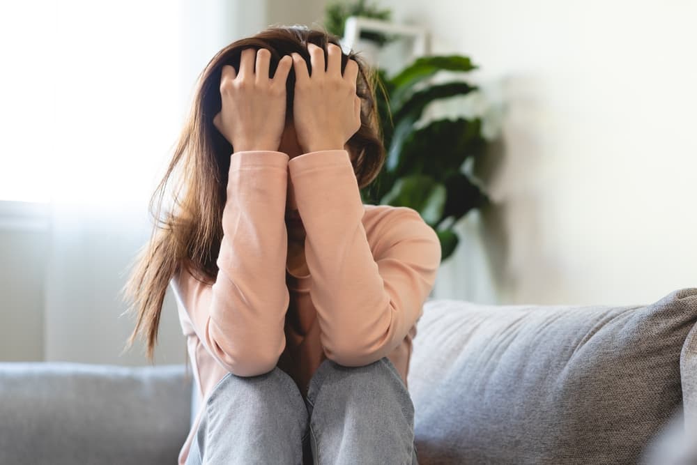 Young women covering her face feeling anxious and unhappy lock themselves at home sad emotional alone