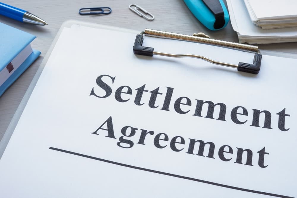 Clipboard with settlement agreement.