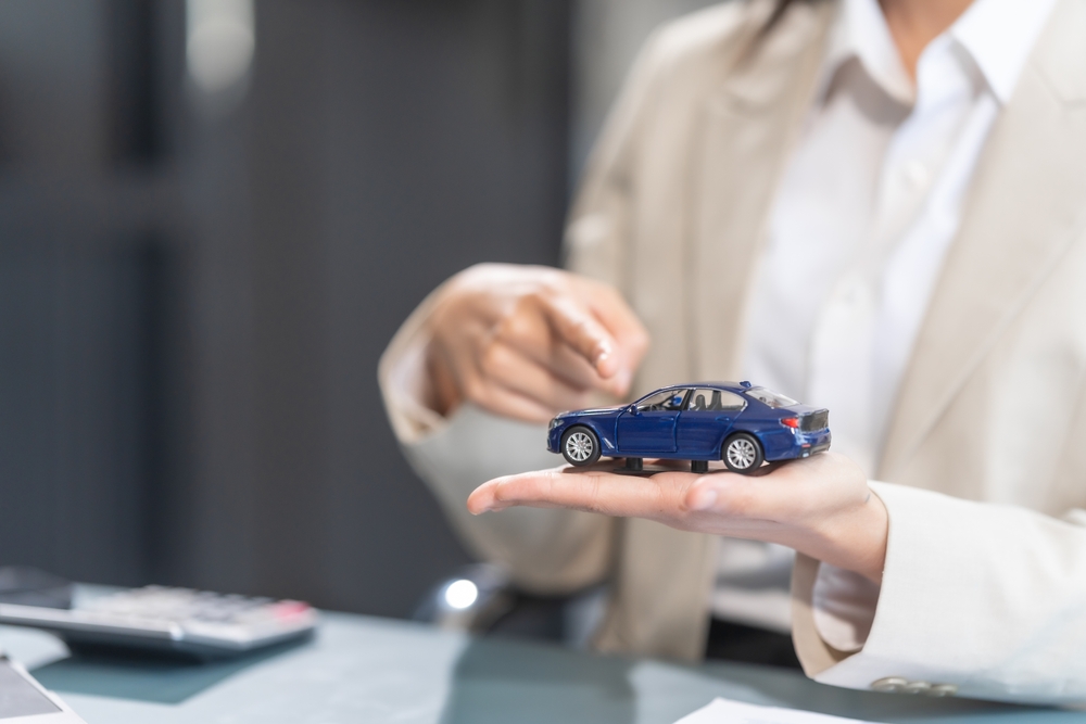 Experienced,Asian,Businesswoman,Adept,In,Car,Insurance,Processes.,Skilled,In A female car accident lawyer holding car model in hand
