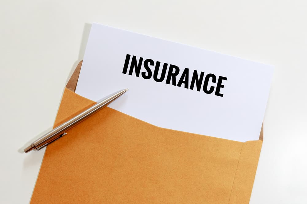 Insurance in envelope with pen on table