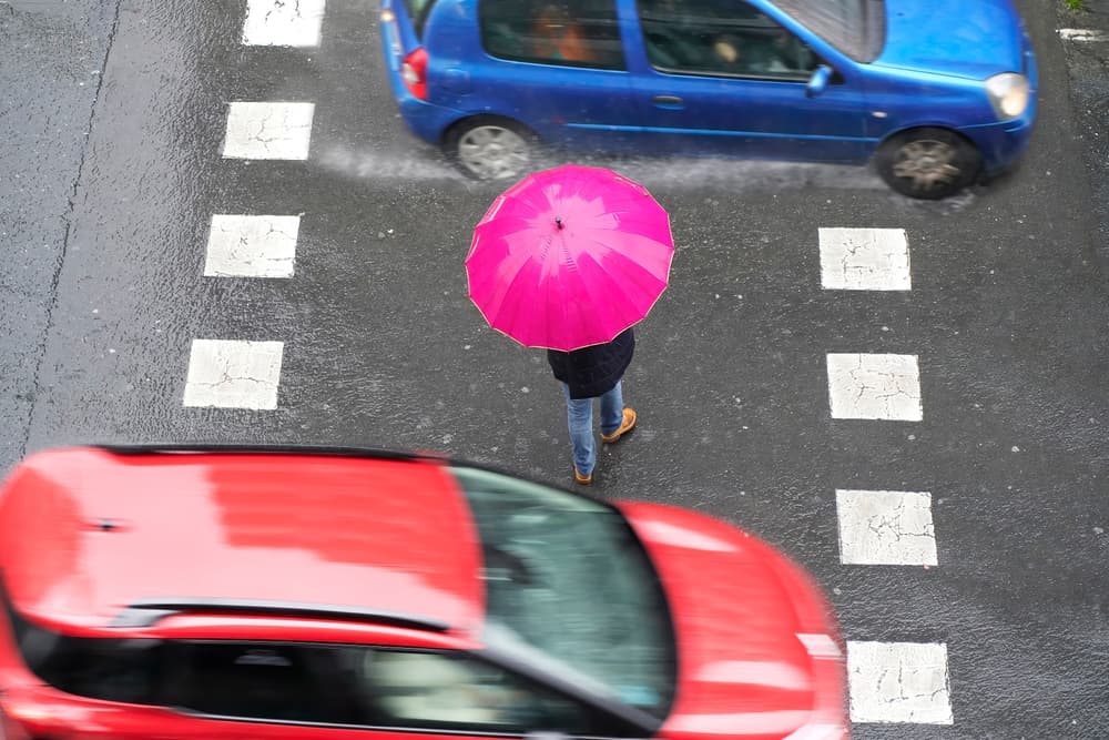 A pedestrian on crosswalk in rainy weather