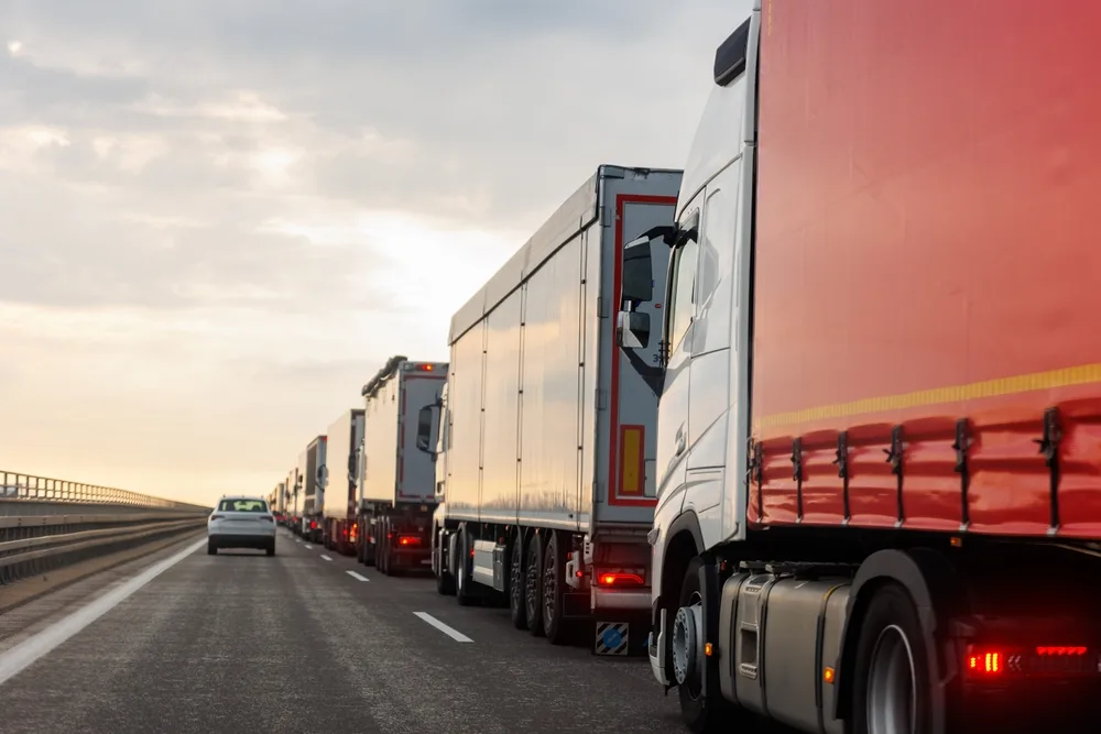 Line of commercial trucks on a highway illustrating trucking company operations and safety responsibilities