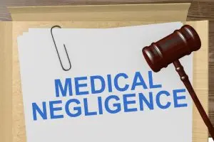 A folder containing papers labeled "Medical Negligence" with a gavel placed beside it, symbolizing legal action in healthcare.