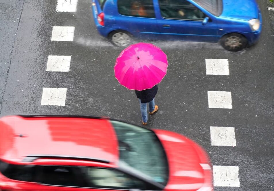 A pedestrian on crosswalk in rainy weather